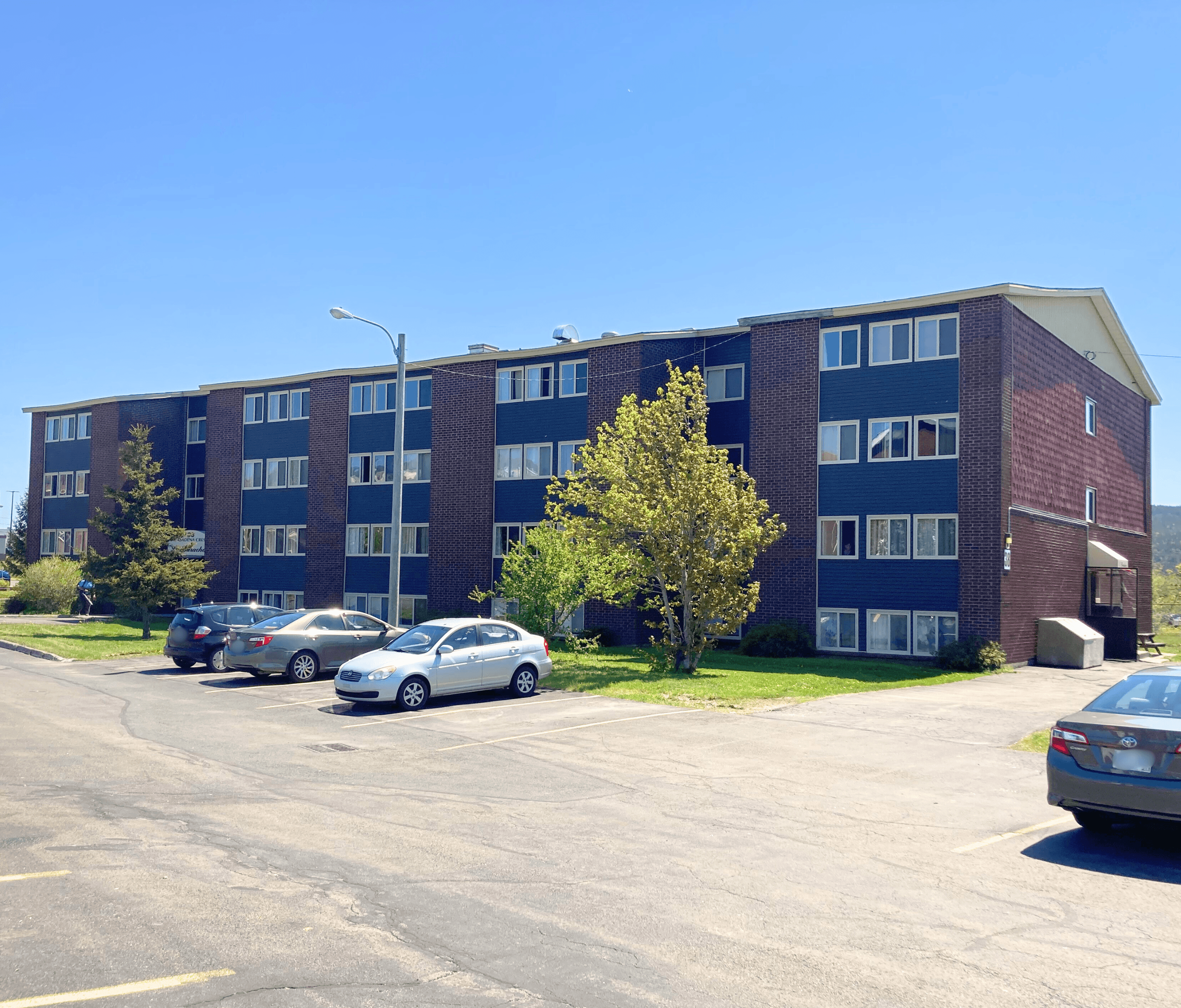 A parking lot with cars and a building in the background.